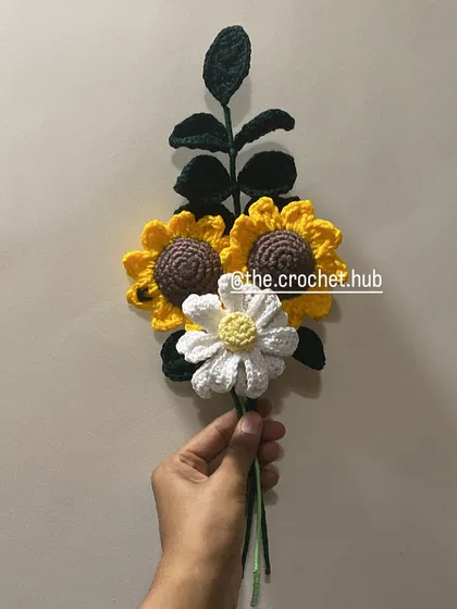 A simple and beautiful arrangement of two sunflowers and a daisy, ready to be wrapped.