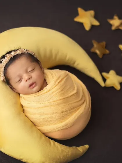 I love you to the moon and back. This celestial theme features a soft moon prop and twinkling stars, perfect for a dreamy and peaceful newborn portrait.