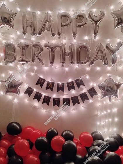 A classic red and black themed birthday wall decoration with fairy lights.