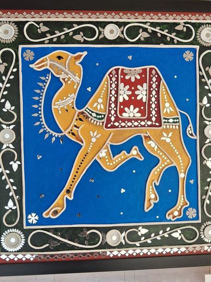 A traditional Rajasthani-style artwork of a camel, adorned with mirror-work, from the 'Aaina' collection.