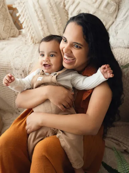 A mother and her baby share a joyful hug. The genuine smiles make this a heartwarming and authentic moment.