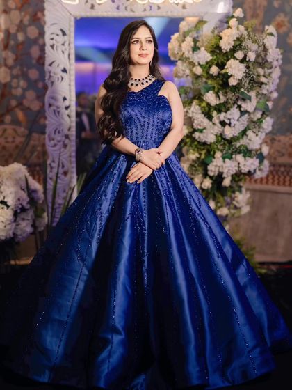 A stunning reception look in a royal blue gown. The makeup is elegant and sophisticated, with a focus on a flawless base and defined eyes.