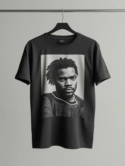 A black t-shirt with a monochrome portrait graphic, shot straight-on against a simple studio background for a clear and focused product image.