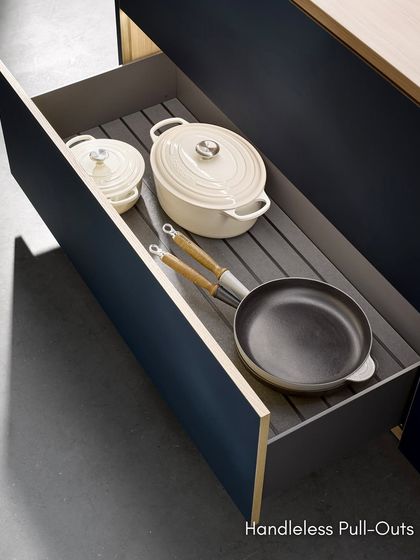 Our handleless pull-out drawers feature non-slip mats to keep pots and pans securely in place. The clean, minimalist exterior hides a highly organized interior.