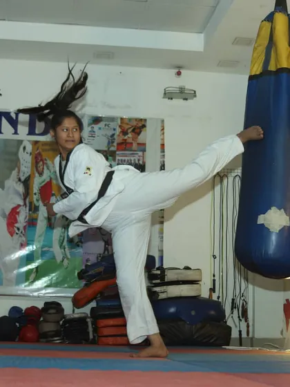 A student practices a powerful side kick on a heavy bag in our dojang. We focus on developing proper form and explosive power in every technique.