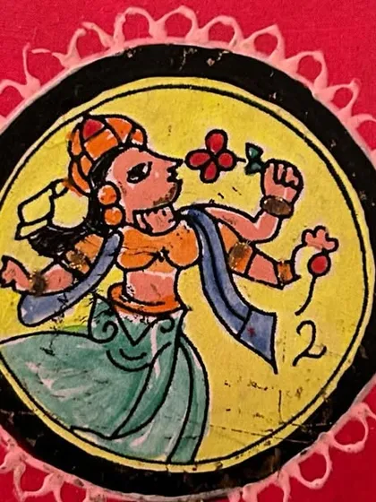 A Ganjifa art coaster featuring a four-armed figure holding flowers. The vibrant colors and distinct line work are characteristic of this beautiful Indian folk art.