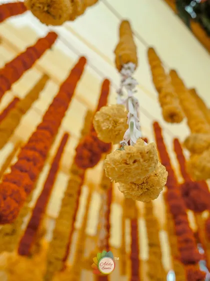 A close-up of hanging marigold garlands, a classic and essential element of traditional Indian wedding decor.