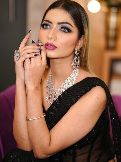 A dramatic pose that highlights the bold eye makeup and perfectly manicured nails. This look is all about confidence and glamour.