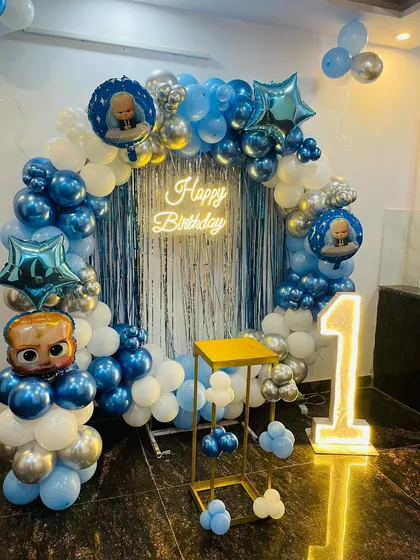 A full view of the Boss Baby themed balloon ring setup, complete with character balloons, a neon sign, and a light-up number, perfect for photos.