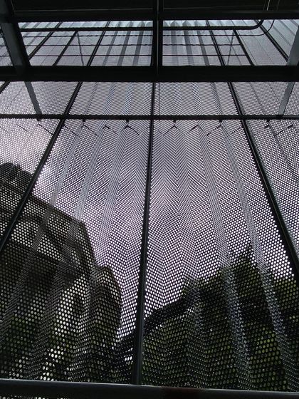 Looking up through the building's new skin, the sky is filtered and the reflection of the historic structure next door is captured. This detail shows how our interventions aim to connect the building to its context in new and unexpected ways.