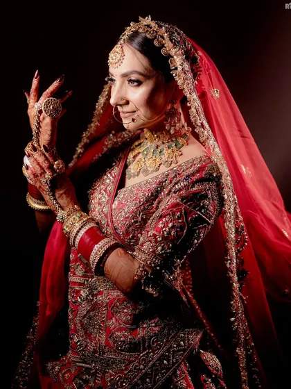 I believe a bridal portrait should be more than just a photo; it should be a reflection of her soul. Using dramatic lighting, I focused on this bride's serene expression and the intricate details of her red lehenga and jewelry, creating a powerful and timeless image.