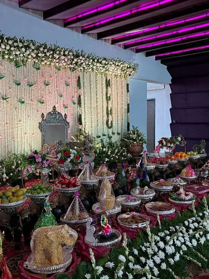 A side view of the white floral stage and its extensive offering table.