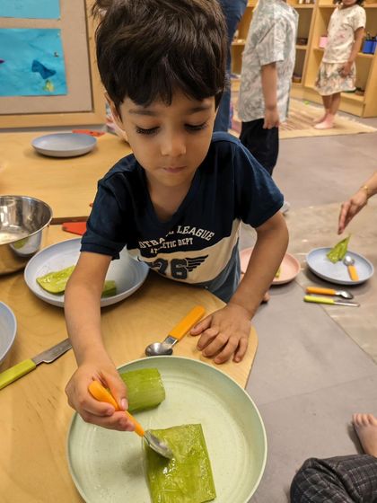 For Mother's Day, children engaged in a multi-sensory culinary project. They scooped aloe vera gel and crushed rose petals to create a special gift. This practical life skill activity also involves measuring, pouring, and mixing.