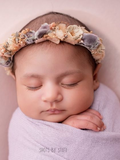 A sweet, chubby-cheeked baby wrapped in a lavender swaddle. This close-up highlights the adorable features that make your baby unique.