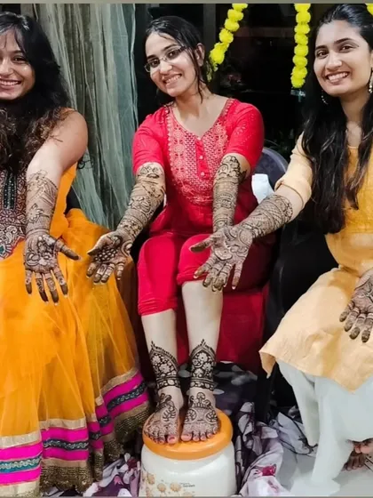 A group of happy clients showing off their intricate mehndi designs after a bridal session.