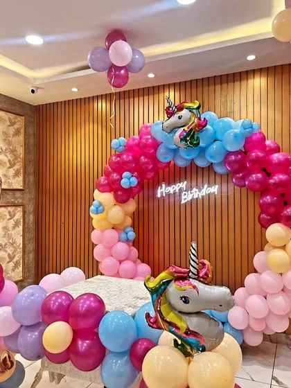 Another take on the popular unicorn theme, this time with a full balloon ring and a large unicorn foil balloon as the centerpiece. The bright pink, blue, and yellow colors make it a fun and vibrant setup for any kid's party.