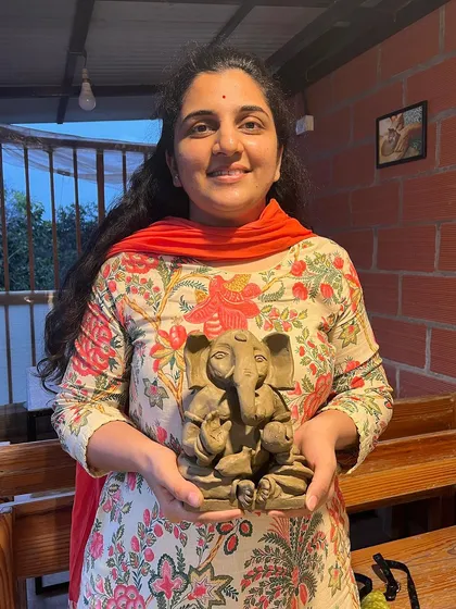 A proud student holding the Ganesha idol she made. The feeling of accomplishment is what makes these workshops so rewarding.