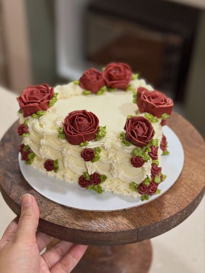 This heart-shaped cake with buttercream roses is a timeless design for any romantic occasion. The deep red of the roses contrasts beautifully with the cream-colored frosting.