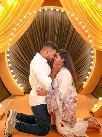 A tender, kneeling pose in front of the golden-lit stage, perfect for a dramatic and romantic photo.