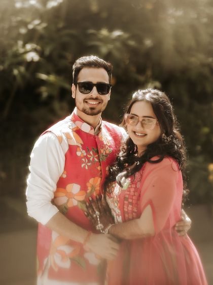 A bright and joyful couple portrait. Their matching sunglasses and big smiles perfectly capture the fun and festive mood of their pre-wedding celebrations.