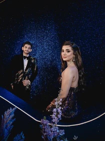 The couple together, captured in a moment of quiet elegance against the starry backdrop, embodying the romantic spirit of their 'Stellar Beginnings'.