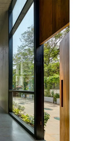 A large wooden door pivots to open up the interior of J-House to the garden, erasing the boundary between inside and out and enhancing the feeling of living within nature.