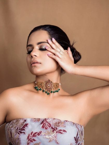 A minimalist beauty portrait focusing on a statement choker and subtle eye makeup. The clean composition and soft lighting draw attention to the model's features and the jewelry.