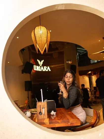 A guest enjoying a quiet moment with a drink at Lumara. My sets cater to everyone, whether you're dancing or just chilling.