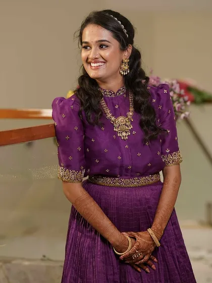 A candid shot of our client smiling, her happiness radiating in our custom purple gown.