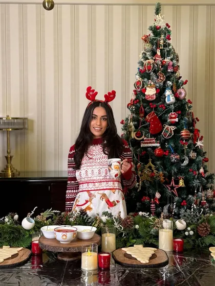 Dressed up in my Christmas sweater, ready to host a holiday party with a table full of my baked goods.