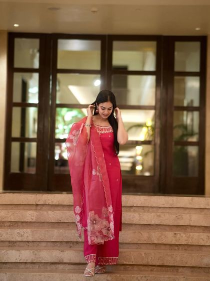 A graceful pose looking down, highlighting the beautiful floral dupatta.
