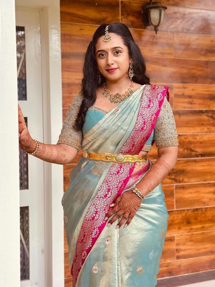 A full-length view of the client in her light blue and pink Kanchivaram saree, paired with a custom gold blouse.