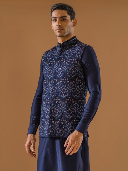 A navy blue Jawahar jacket with a subtle, elegant print, layered over a matching navy kurta. This monochromatic pairing is a sophisticated choice for an evening event.