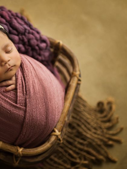 A creative angle of the baby in the basket, using negative space to create an artistic and modern feel.