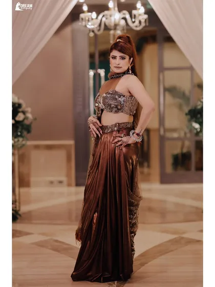 A full-length portrait of Kirti in a stunning metallic brown saree, exuding glamour and confidence.