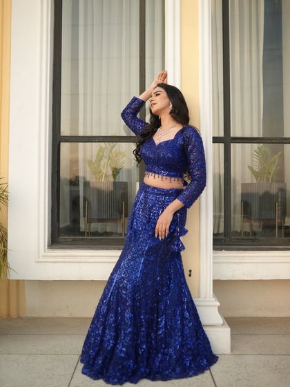 A dramatic pose that highlights the modern cut and glamorous feel of this evening wear lehenga.