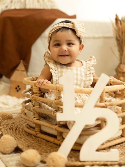 A close-up of a baby celebrating her half-birthday, with the '1/2' sign in the foreground.
