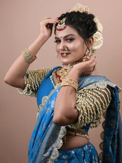 This shot highlights the intricate blouse design and the elegant hairstyle with white flowers.