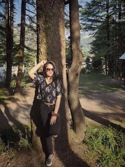 A casual, relaxed look for a sunny day in the forest, featuring a printed top and black jeans.