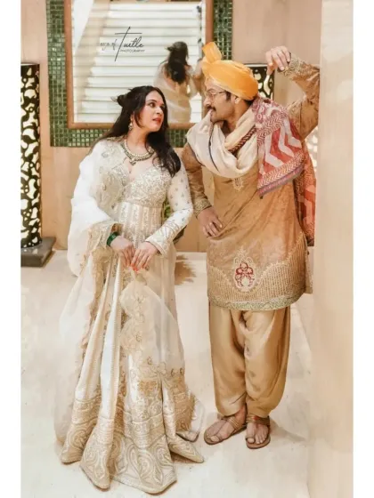 A candid interaction between the bride and groom. His playful gesture and her loving gaze create a portrait that is full of personality and charm.