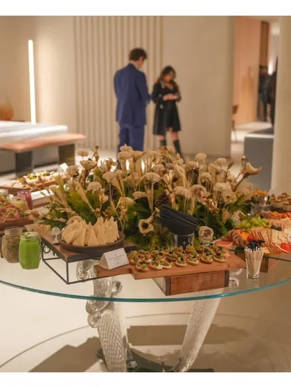 A grazing table set up on a modern glass table for a store launch event. We can adapt our setups to any venue style, from rustic outdoor to chic and contemporary indoor spaces.