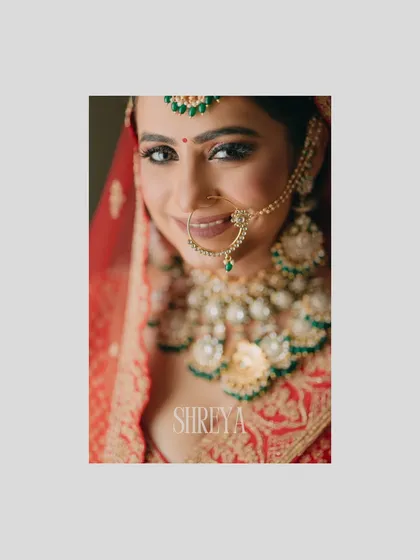 A beautiful close-up of bride Shreya, her smile radiating happiness. This portrait focuses on her expressive eyes and the stunning details of her bridal jewelry.