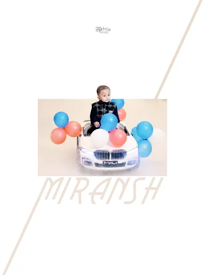 For Miransh's first birthday, we did a clean and bright indoor photoshoot. Using controlled lighting and fun props like this toy car and balloons, I create classic, posed portraits that make for timeless keepsakes. The final image includes a custom graphic with his name.