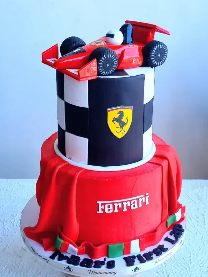 This two-tiered Ferrari cake is perfect for a young racing fan. It features a hand-sculpted fondant race car, a checkered flag pattern, and a draped fabric effect, all made from sugar.