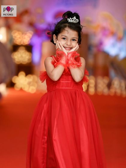 An adorable, expressive portrait of the birthday girl, framed by the soft, blurred lights of the party decor.