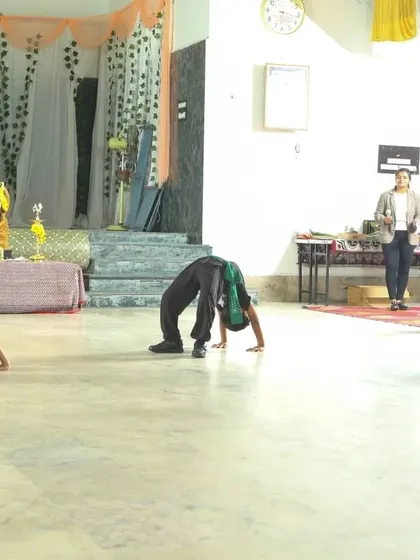 A proud moment from our black belt ceremony. My students demonstrate advanced flexibility and control with poses like Chakrasana (Wheel Pose), showcasing the results of their dedicated training.
