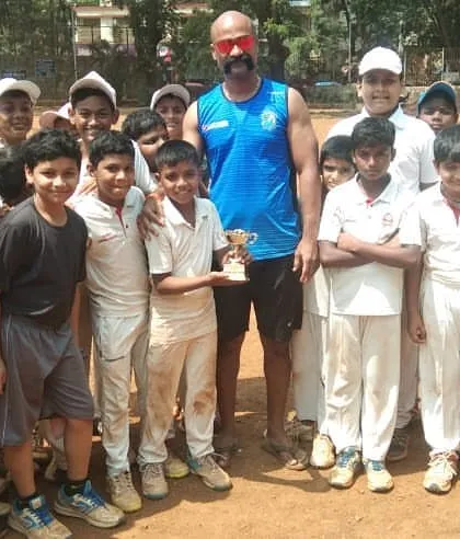 Vighnesh Shinde awarded 'Man of the Match' in our internal DSCA tournament, surrounded by his teammates and coaches.