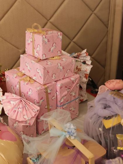 Stacks of pink unicorn-themed gift boxes, perfectly wrapped and ready for a baby shower. The consistent theme makes the gift table look cohesive and absolutely magical.