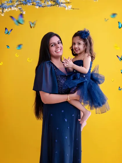 My studio offers a range of vibrant backdrops to match your family's personality. The bright yellow here contrasts beautifully with the matching blue outfits, creating a cheerful and eye-catching mother-daughter portrait.