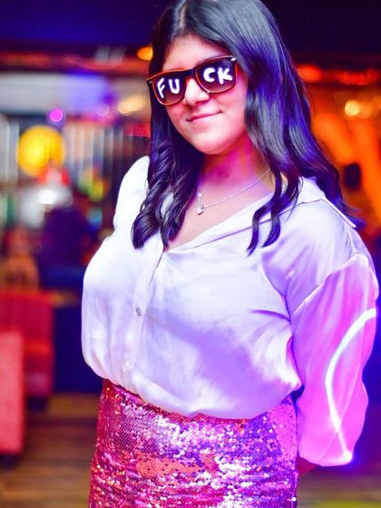 Rocking some fun shades and a sequin skirt, this partygoer embodies the fun and carefree spirit of Ladies' Night.